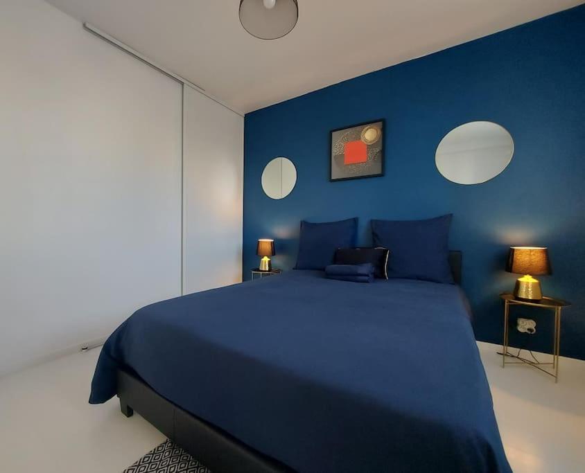 德勒LE CHIC ETHNIC DREUX 52m2 - 50 MIN DE PARIS - PARKING GRATUIT的蓝色卧室设有一张带蓝色墙壁的大床