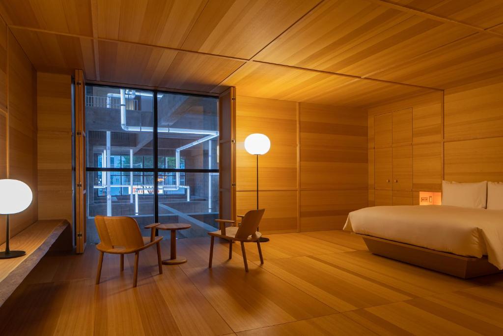 前桥市SHIROIYA HOTEL的一间卧室配有床、椅子和窗户