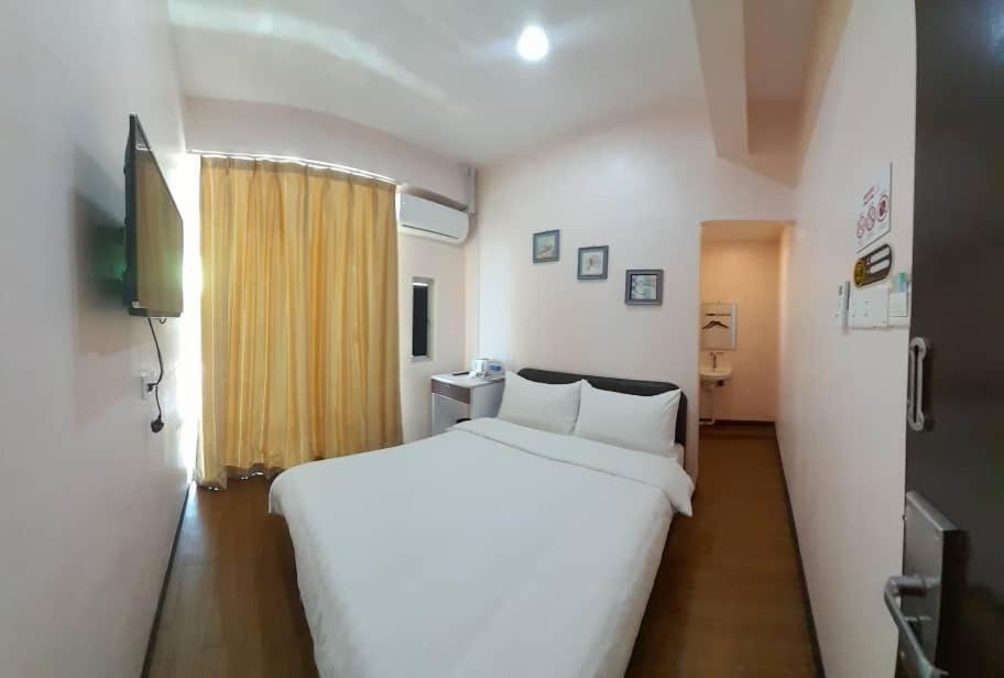 仙本那Sipadan Crystal Haven Inn的卧室设有一张白色大床和一扇窗户。