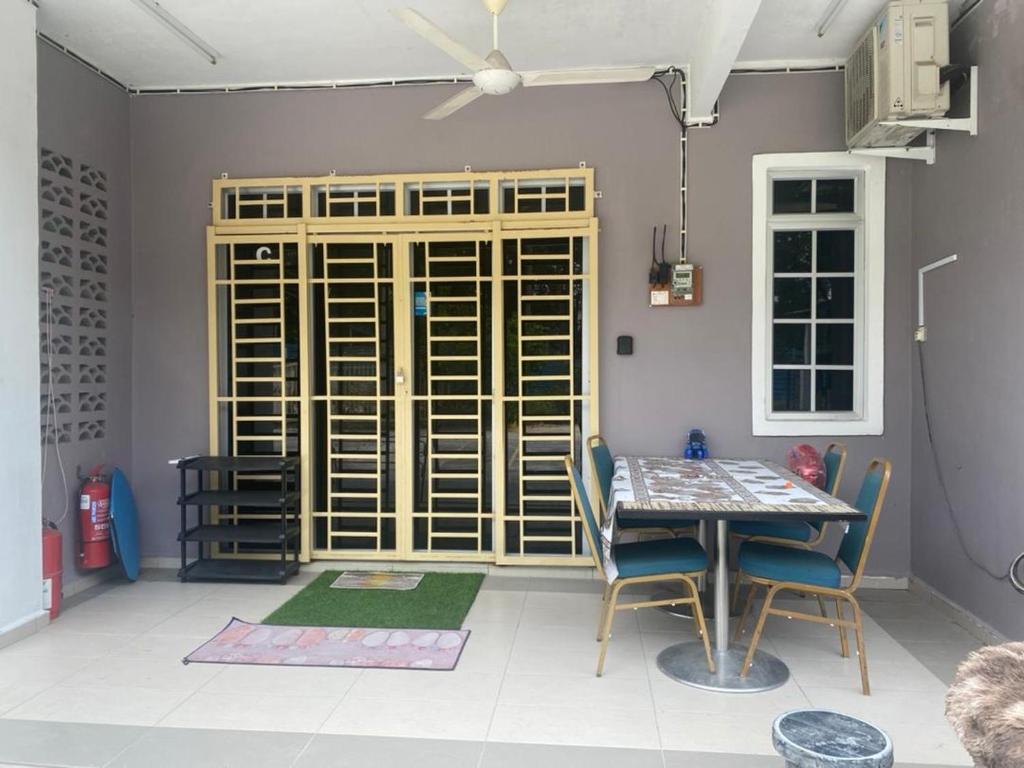 Kampong Alor GajahHomestay Zalida C Musleem的一间带桌椅和窗户的用餐室