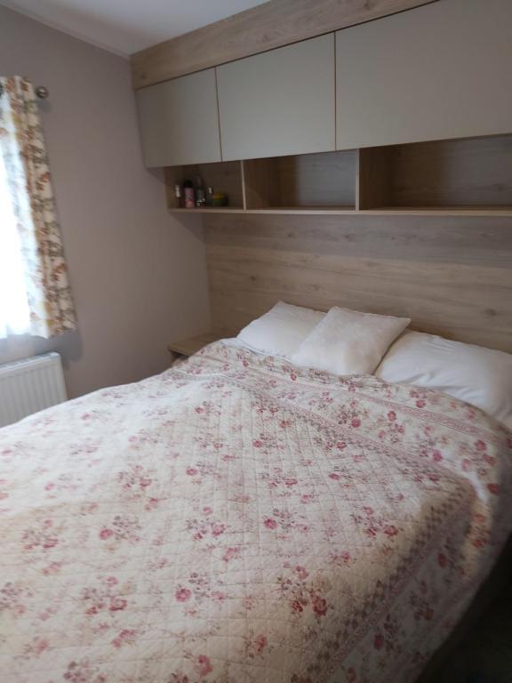 查茅斯Wood Farm Holiday Park的一间卧室配有一张带红白毯子的床