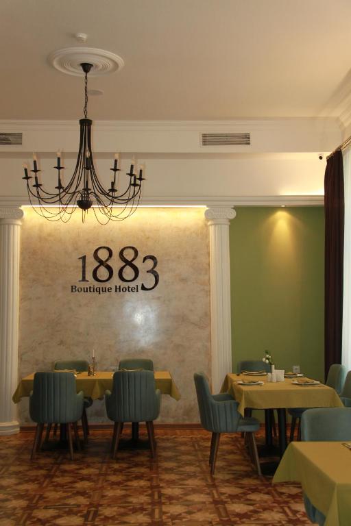 巴库Hotel 1883的一间带桌椅和吊灯的用餐室