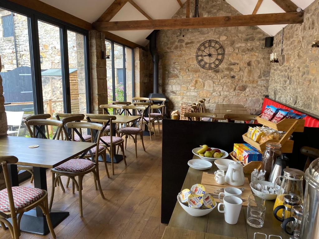 莫珀斯The Star Inn - Harbottle - Near Rothbury - Northumberland的餐厅设有桌椅和窗户。