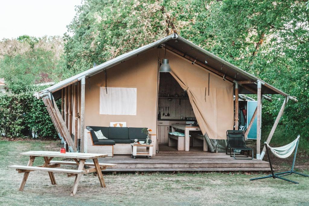 霍尔滕Glamping Holten luxe safaritent 1的帐篷前设有长凳和桌子