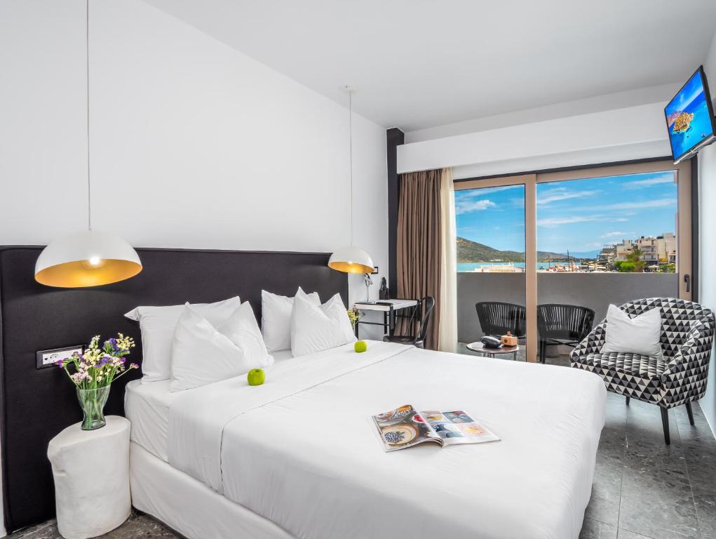 伊罗达Kalypso Suites Hotel - Adults Only的一间卧室设有一张大白色的床,享有美景。