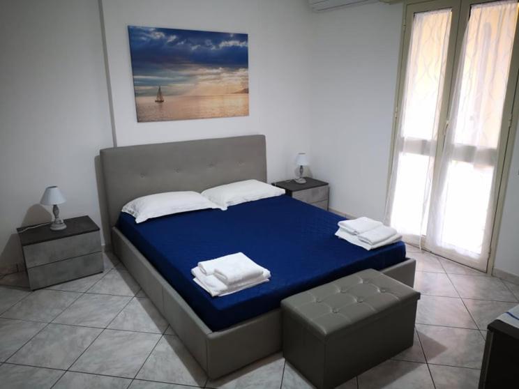 马尔扎梅米The Sail Apartment - Marzamemi的一间卧室配有一张带蓝色床单和白色枕头的床。