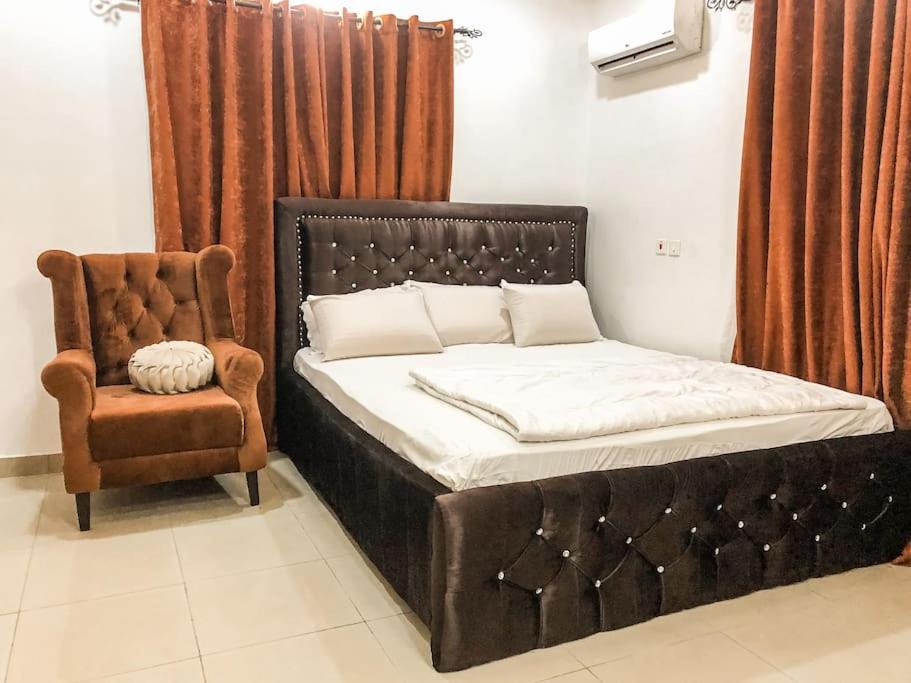 阿布贾Cozy 1 bedroom apartment in Abuja的房间里的一张床和椅子