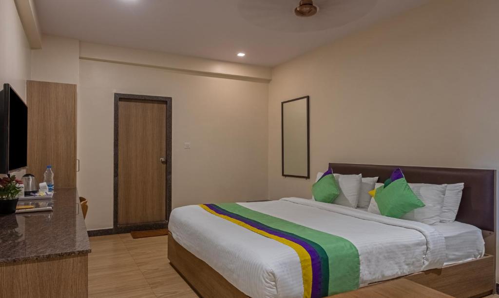 维沙卡帕特南Treebo Trend Seasons Comfort的卧室配有一张带彩色枕头的大型白色床。