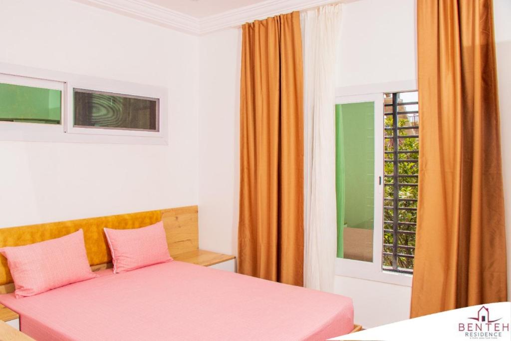 班珠尔Benteh 2的卧室配有粉红色的床和窗户。