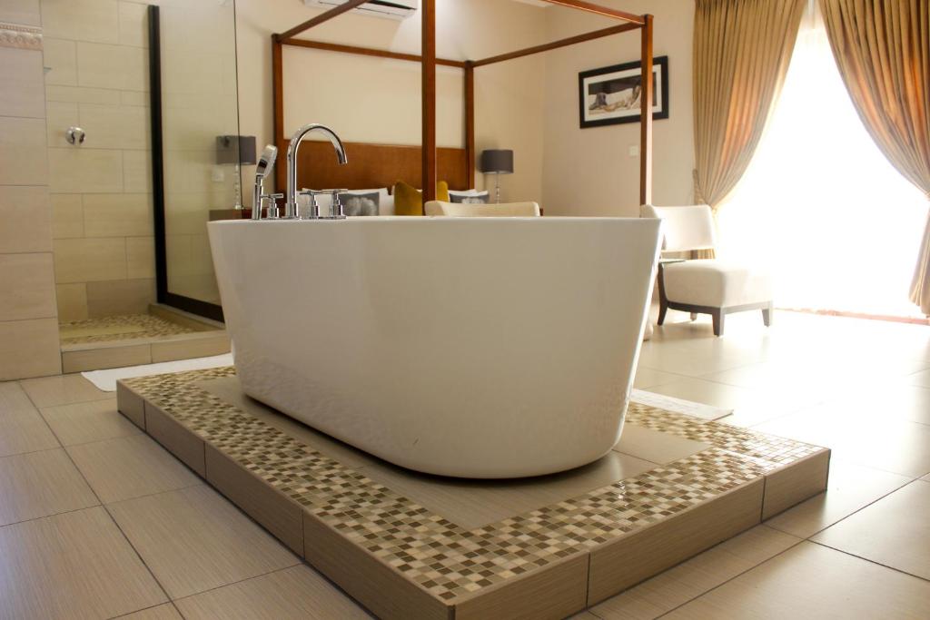 马翁SteyMorr Guesthouse的带浴缸的浴室,位于瓷砖地板