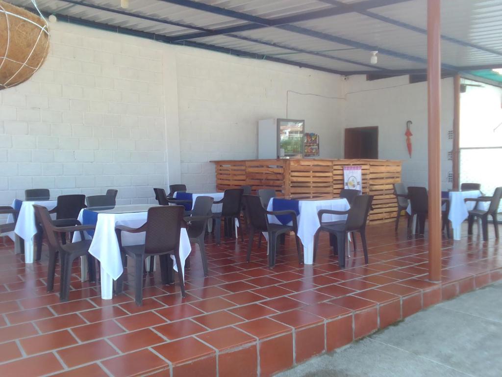 ChinácotaHotel La Casona的一间设有桌椅的房间,配有蓝色和白色的桌布
