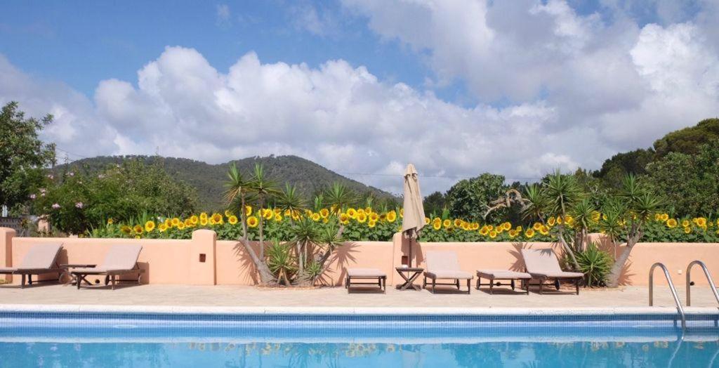 圣卡洛斯波德里奥餐厅旅馆的一个带椅子和遮阳伞的度假村游泳池