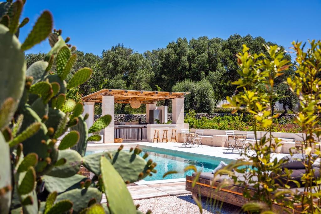奥斯图尼Villa Gufo的一个带游泳池和凉亭的后院