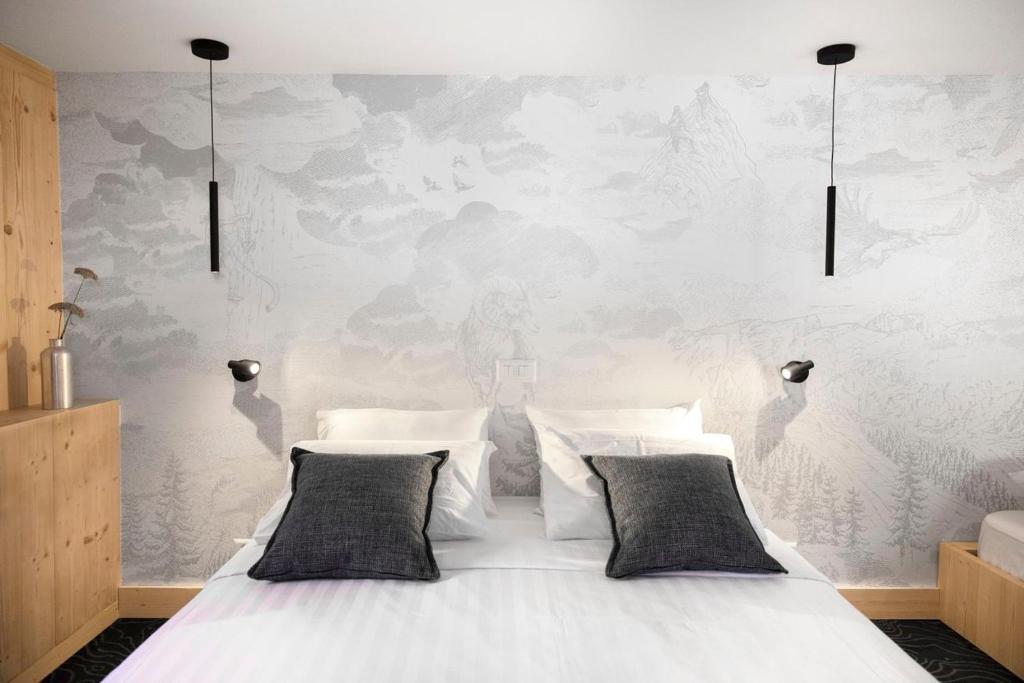 格里翁Miroir d'Argentine的卧室内的一张带两个枕头的白色床