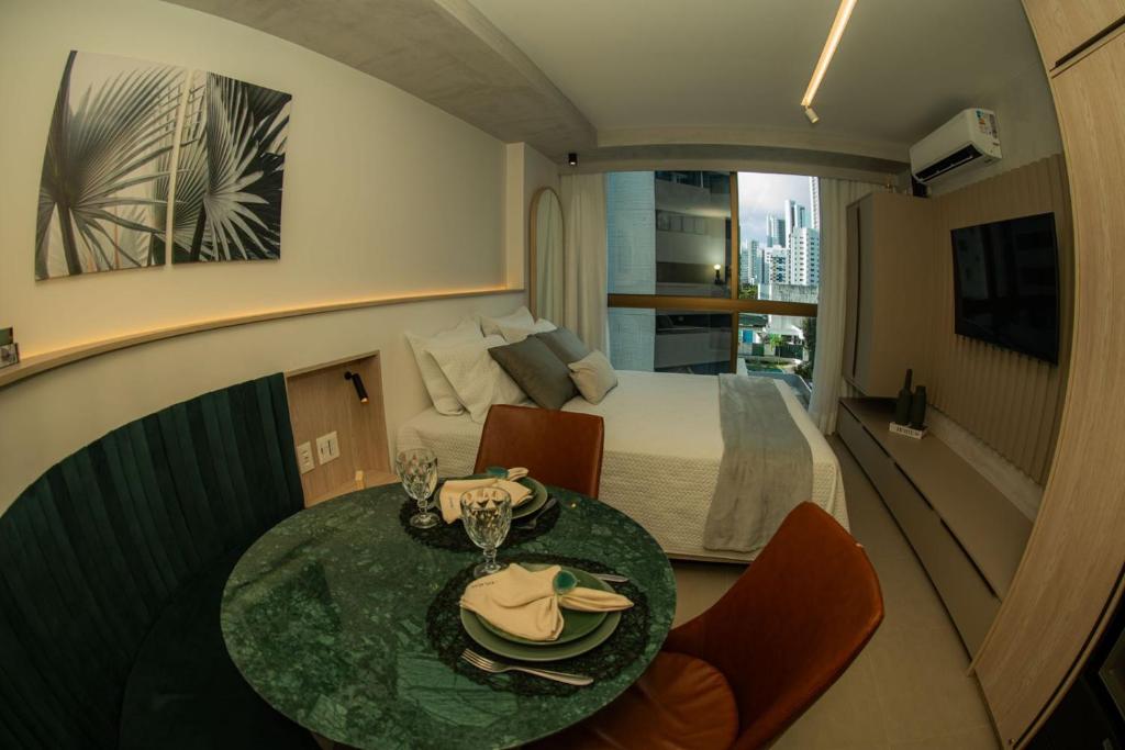 累西腓BOA VIAGEM - FLAT ROOFTOP ALTO PADRÃO的酒店客房配有一张床和一张桌子,桌子上装有四面 ⁇ 