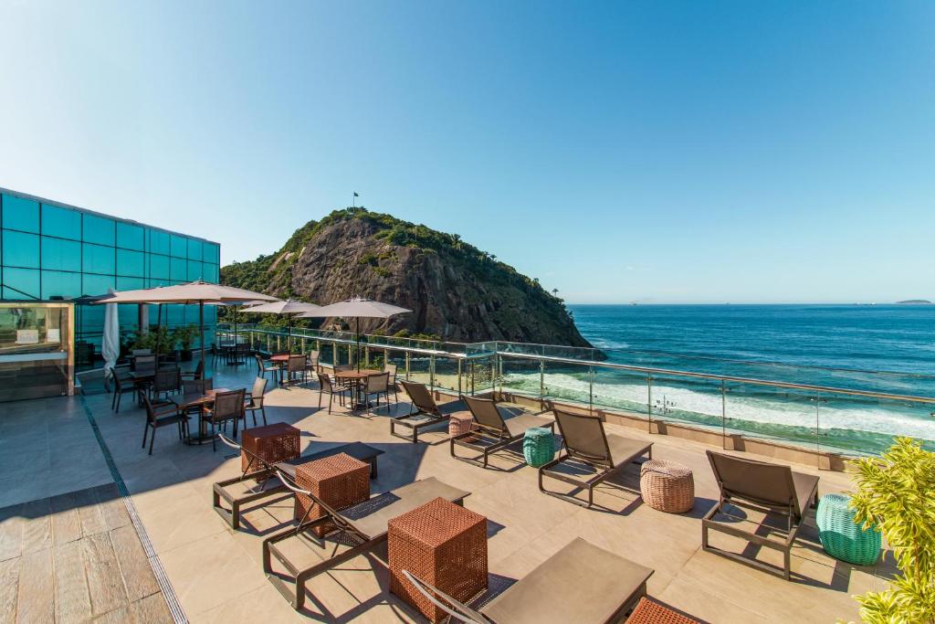 里约热内卢勒梅竞技场酒店 的一个带桌椅的庭院和大海