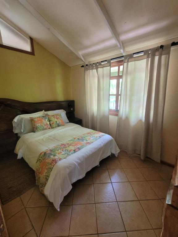 乌维塔Cabina Rancho la Merced的一间卧室配有一张带白色床单的床和一扇窗户。