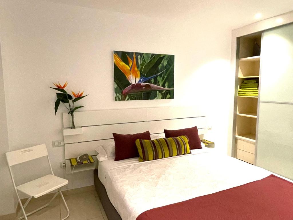 滨海帕尔姆Casa Las Olas的卧室配有一张床,墙上挂有绘画作品