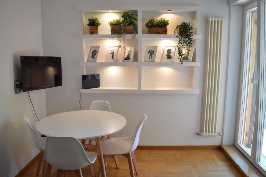 罗马Domi - Appartamento Roma的一间配备有白色桌椅的用餐室