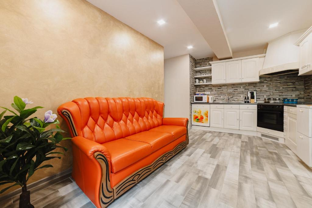 布拉索夫Noua Oasis BNB with PARKING的厨房里配有橙色的皮沙发,配有白色的橱柜