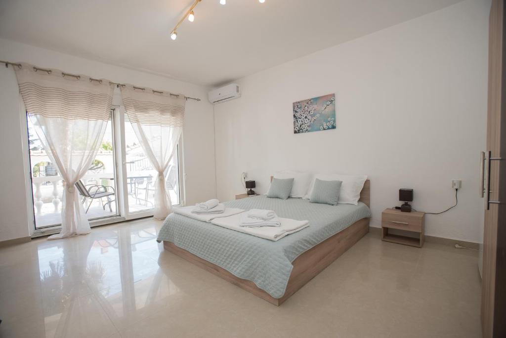 盖夫盖利亚Three Palms的白色的卧室设有床和大窗户
