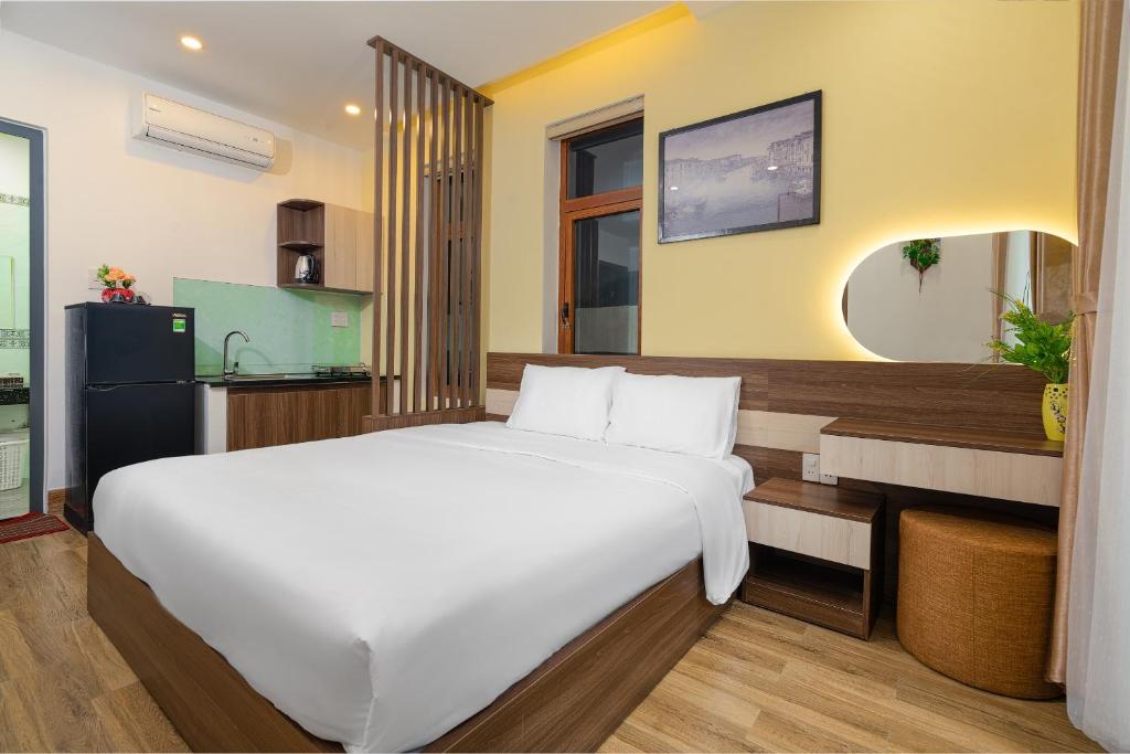 岘港Nguyên Hương Hotel的一间带白色大床的卧室和一间厨房