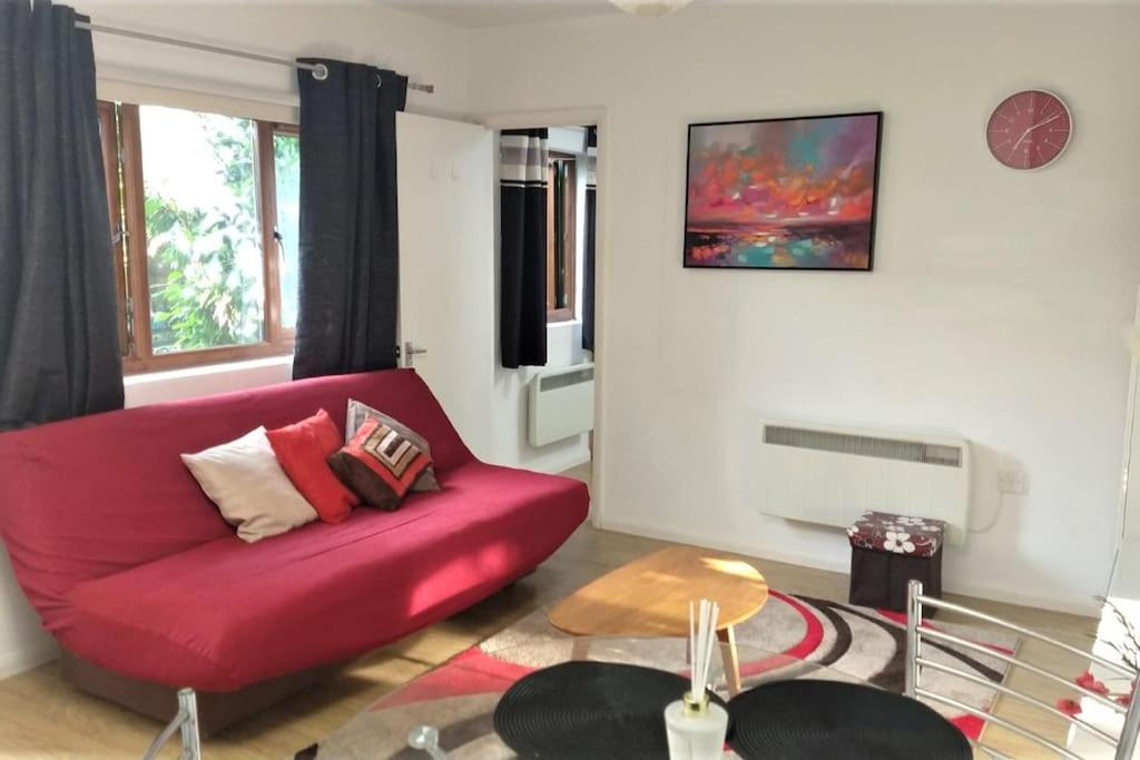 Cherry HintonModern Spacious Detached Cottage in Cambridge的客厅配有红色的沙发和桌子