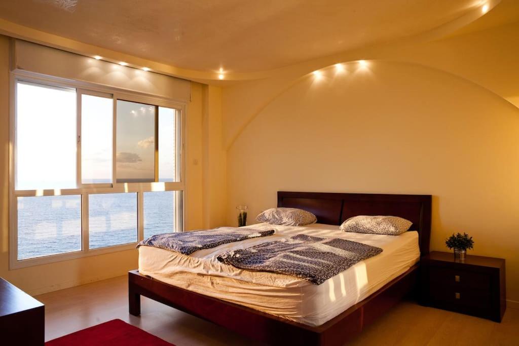 内坦亚尼茨萨海景公寓的一间卧室设有一张大床和大窗户