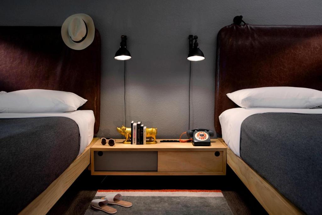 坦培凤凰城寺／ASU区慕奇夕酒店的一间卧室配有两张床,中间设有床头柜。