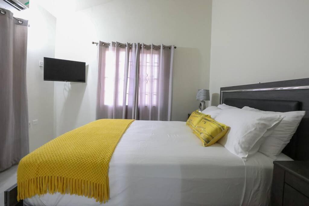 迪斯卡弗里贝Osmax Oasis entire house/2 bedrooms!的一间卧室配有一张黄色毯子床