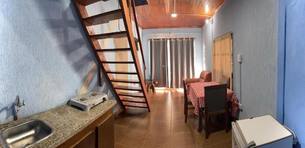 伊瓜苏港Hosteria NAMAJU的厨房设有螺旋楼梯,通往用餐室