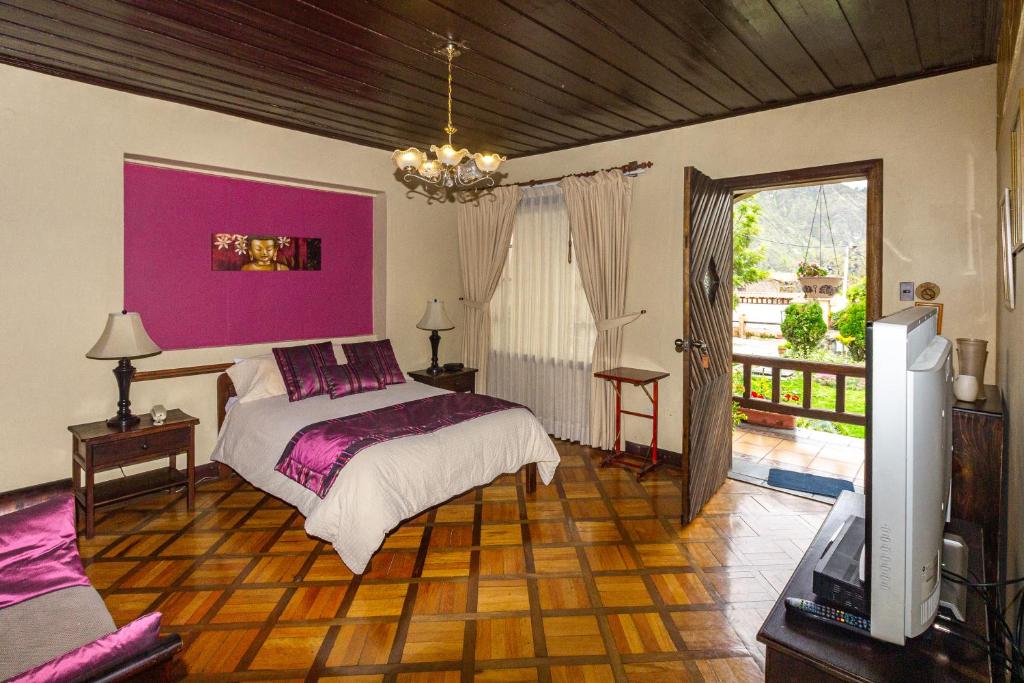 安巴托QUINTA LOREN HOSTERIA的一间卧室配有一张床和粉红色的墙壁