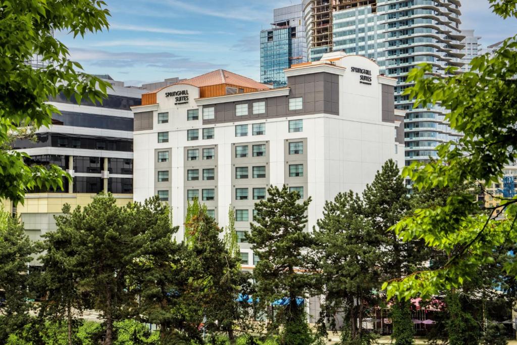 西雅图西雅图市区春山套房酒店的一座白色的建筑,高楼前有树木