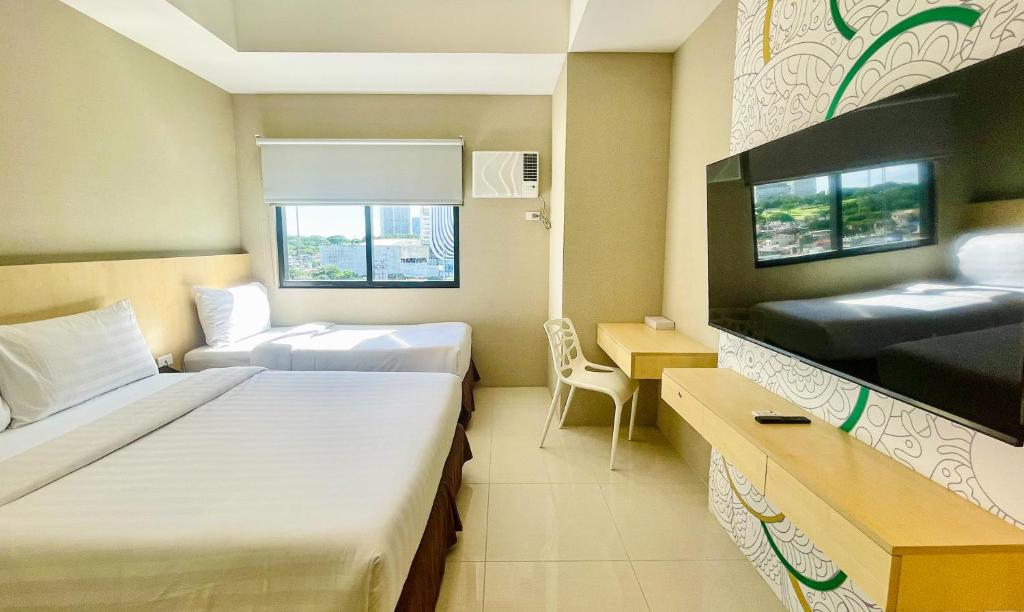 马尼拉Hotel101 - Fort的酒店客房设有两张床和电视。