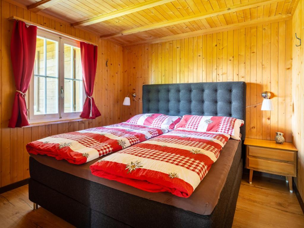 阿克斯普Chalet am Sunne-Egge auf Axalp bei Brienz的木墙客房内的一张大床
