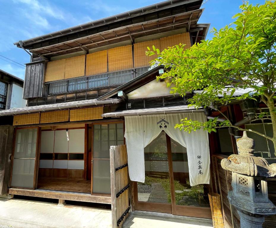 镰仓市古民家の宿 鎌倉楽庵 - Kamakura Rakuan -的前面有窗帘的建筑