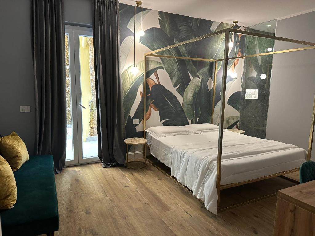 阿格里真托Krysos Luxury Rooms的一间卧室配有一张天蓬床,墙上挂有绘画作品