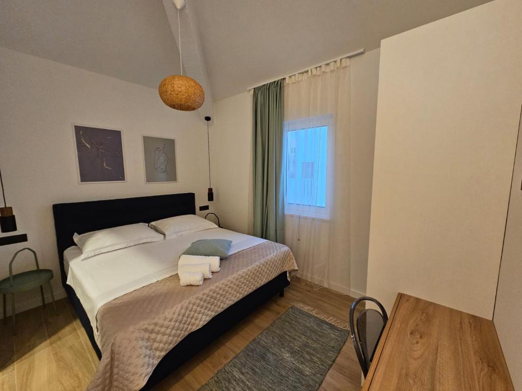 罗戈兹尼察Villa LUX Apartments的一间卧室配有一张床,上面有两条毛巾