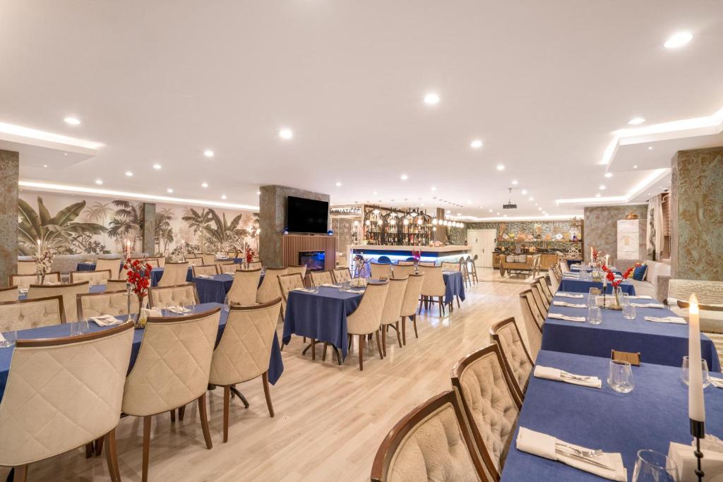 卡尔斯GRAND ANİ HOTEL的一间配备有蓝色桌椅的用餐室
