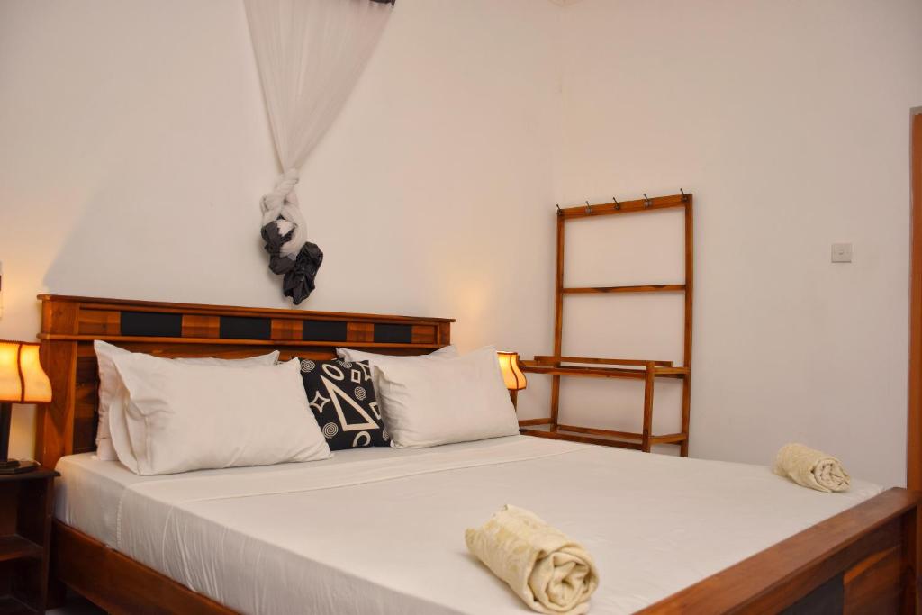 锡吉里亚Sunrise Cottage的一间卧室配有带白色床单和枕头的床。
