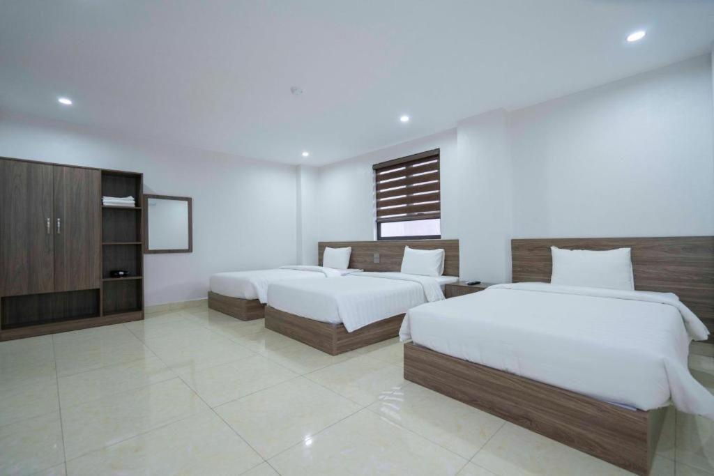 下龙湾AURORA BÃI CHÁY HẠ LONG的一间酒店客房,设有两张床和电视