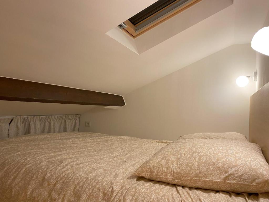 PomponneThe Little Oak - tiny house with bed on mezzanine & terrace - from 1 to 4 p Disney JO Paris的一间卧室配有一张带白色床罩的床