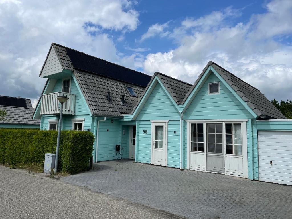 KropswoldeVrijstaande luxe Finse blokhut 2-6 of 2-8 pers的蓝色和白色的房子,设有车库