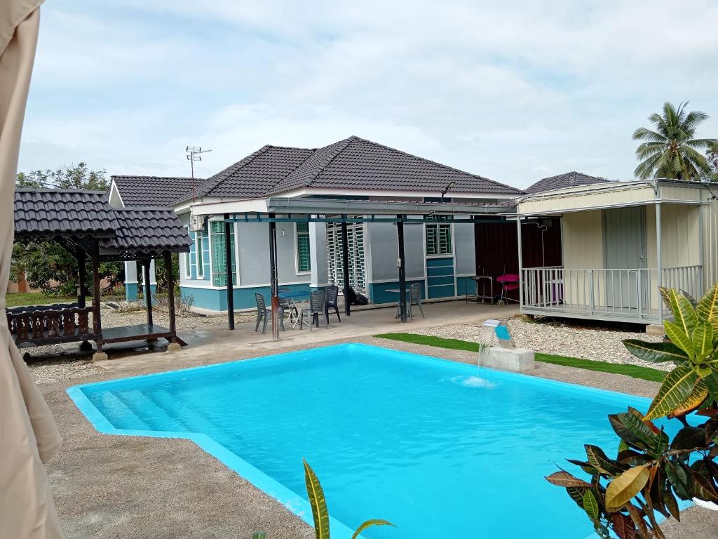 双溪大年Homestay Pinang Tunggal的别墅前设有游泳池