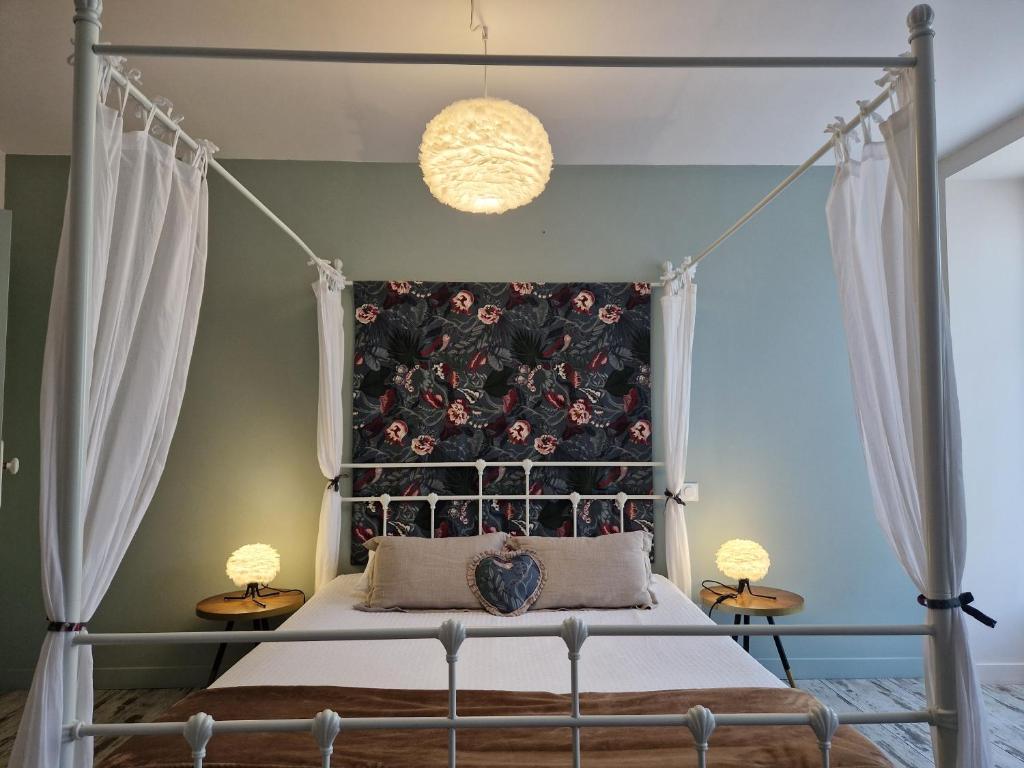 PupillinUNE AUTRE MAISON Chambres d'hôtes的一间卧室配有一张天蓬床和两盏灯。