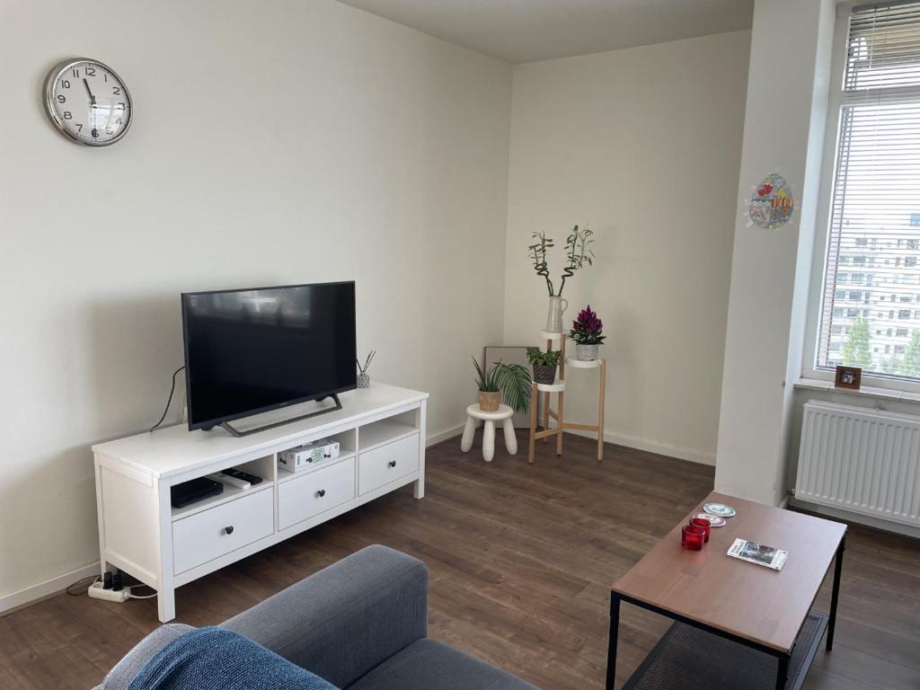 吕伐登Apartment with city skyline的客厅配有白色橱柜上的平面电视