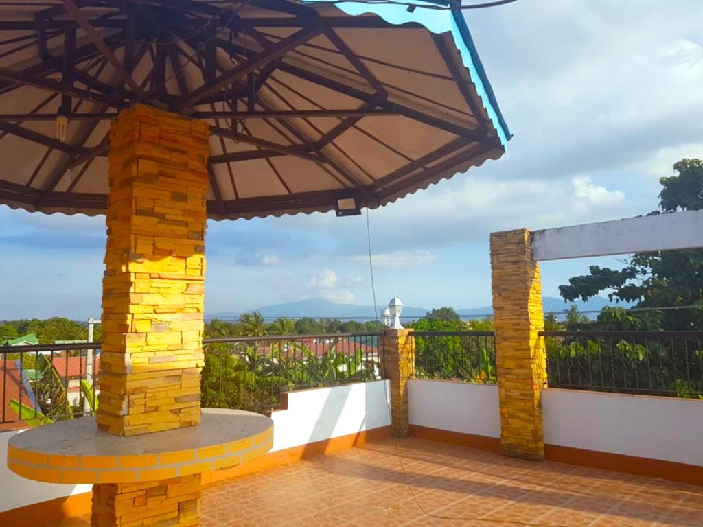 八打雁Rooftop Inn Bauan Batangas的一个带桌子和大雨伞的庭院