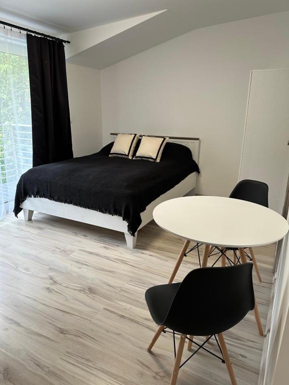 维斯瓦Roomflacja的卧室配有一张床和一张桌子及椅子