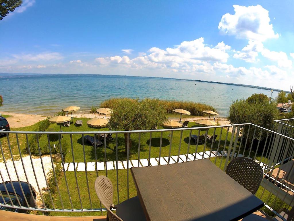 西尔米奥奈Smeraldo dip Villa Canneto的阳台配有桌子,享有海景。