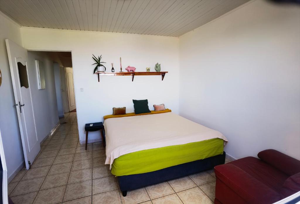 勒唐蓬La case ludovic的一间带一张床铺的卧室,位于一个带沙发的房间